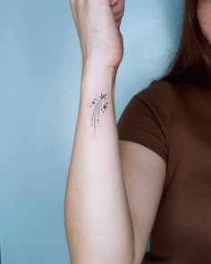 a woman with a small star tattoo on her left arm and right arm behind her head