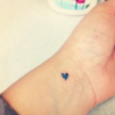 a small heart tattoo on the wrist is seen in this image, it appears to be tiny
