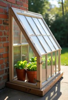 a small greenhouse with plants growing in the window and on the side of a brick building