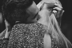 black and white photograph of a man kissing a woman's head with her hair in ponytail