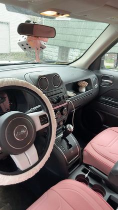 the interior of a car with pink leather seats and steering wheel covers, including a plush dog