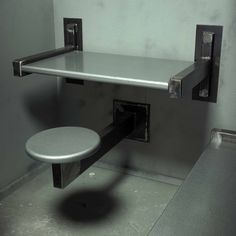 a metal shelf with two hooks on it and a stool in the corner next to it
