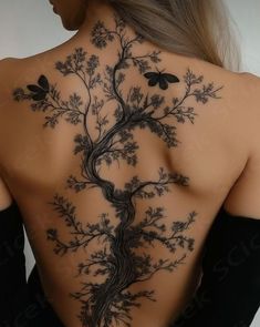 the back of a woman's body with tattoos on it