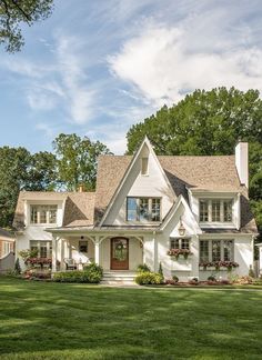 a large white house sitting on top of a lush green field