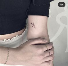 a woman's arm with a small star tattoo on it