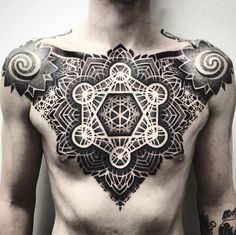 a man's chest with an intricate tattoo design on his chest and chest area