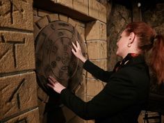 a woman with red hair is touching a stone wall