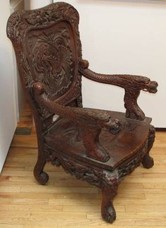 an old wooden chair sitting on top of a hard wood floor next to a white wall