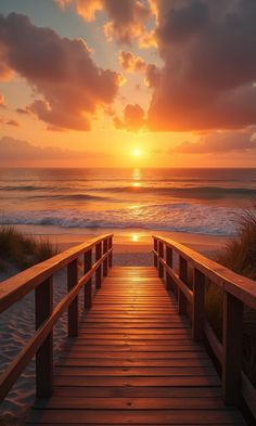 a wooden walkway leading to the beach at sunset