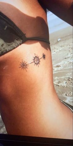 a woman's stomach with a tattoo on the side of her body and sunflowers