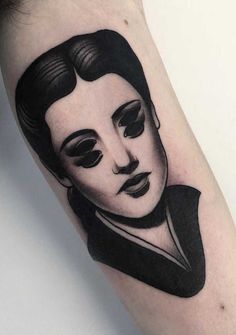 a black and white portrait tattoo on the arm