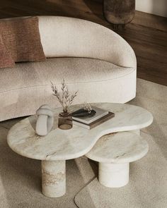 a white marble coffee table sitting on top of a rug