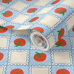 a blue and white wrapping paper with red tomatoes on it, next to a roll of tape