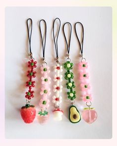 four different necklaces with fruits and vegetables attached to each beaded strander, on a white background