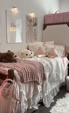 there is a bed with pink sheets and teddy bears on the headboard in this bedroom