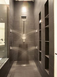a very long narrow bathroom with some lights on the ceiling and no one in it