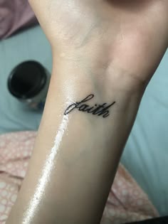 a person with a tattoo on their arm that says faith