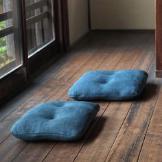two blue cushions sit on the floor next to each other