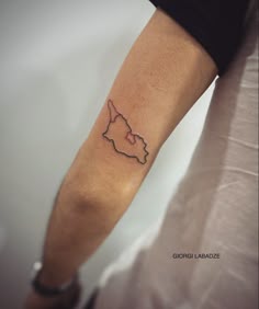 a person's arm with a small map tattoo on the left side of it