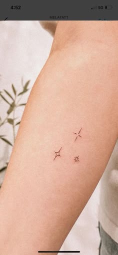 a woman's arm with three small stars on the left side of her arm