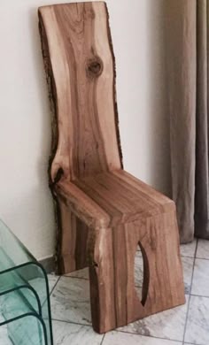 a wooden chair sitting on top of a white tiled floor next to a glass table