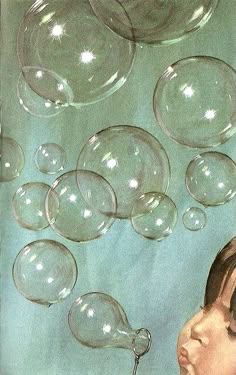 a young boy blowing soap bubbles into the air on a blue background with white stars