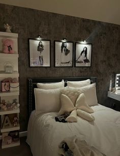 a white bed sitting in a bedroom next to two pictures on the wall above it