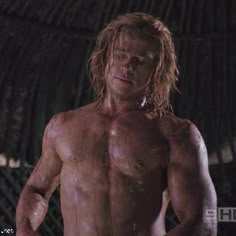 a shirtless man with no shirt standing in front of a fenced off area