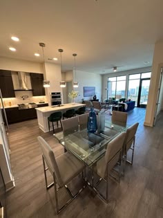 an open floor plan living room and dining area with glass top table in the foreground