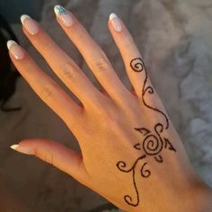 a woman's hand with a tattoo design on the middle of her left hand