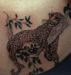 a woman's back with a tattoo of a leopard on it
