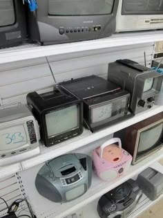 there are many old televisions on the shelves