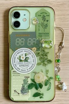 a cell phone case with flowers and plants on the back is sitting on a table