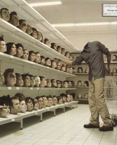 a man standing in front of shelves filled with mannequin heads