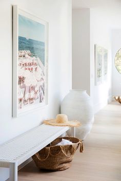 there is a hat on the bench in this room with white walls and wood flooring
