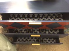 three drawers are stacked on top of each other with decorative designs painted on the sides