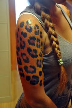 a woman with a leopard print tattoo on her arm and shoulder is looking at the camera