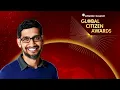 A video of Sundar Pichai delivering his acceptance remarks at the Atlantic Council global citizen awards. He is wearing a black tuxedo, standing at a lectern on a stage with a red backdrop.