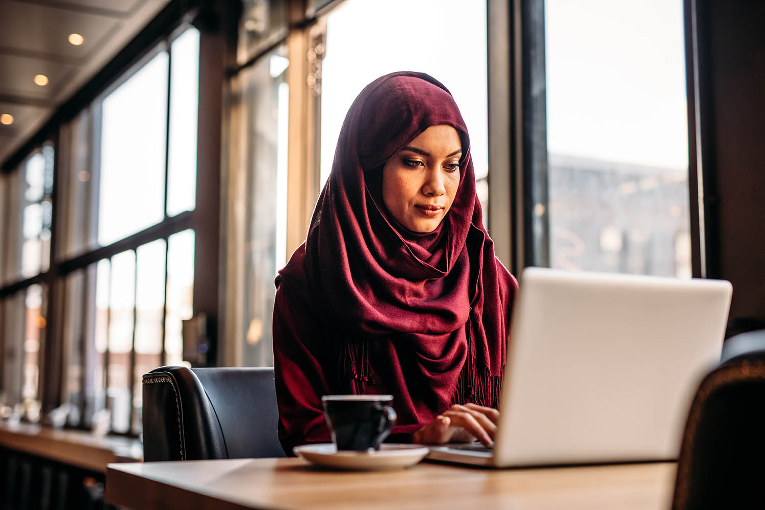Businesswoman in hijab working on laptop