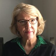 A photo of a woman with short hair and glasses.