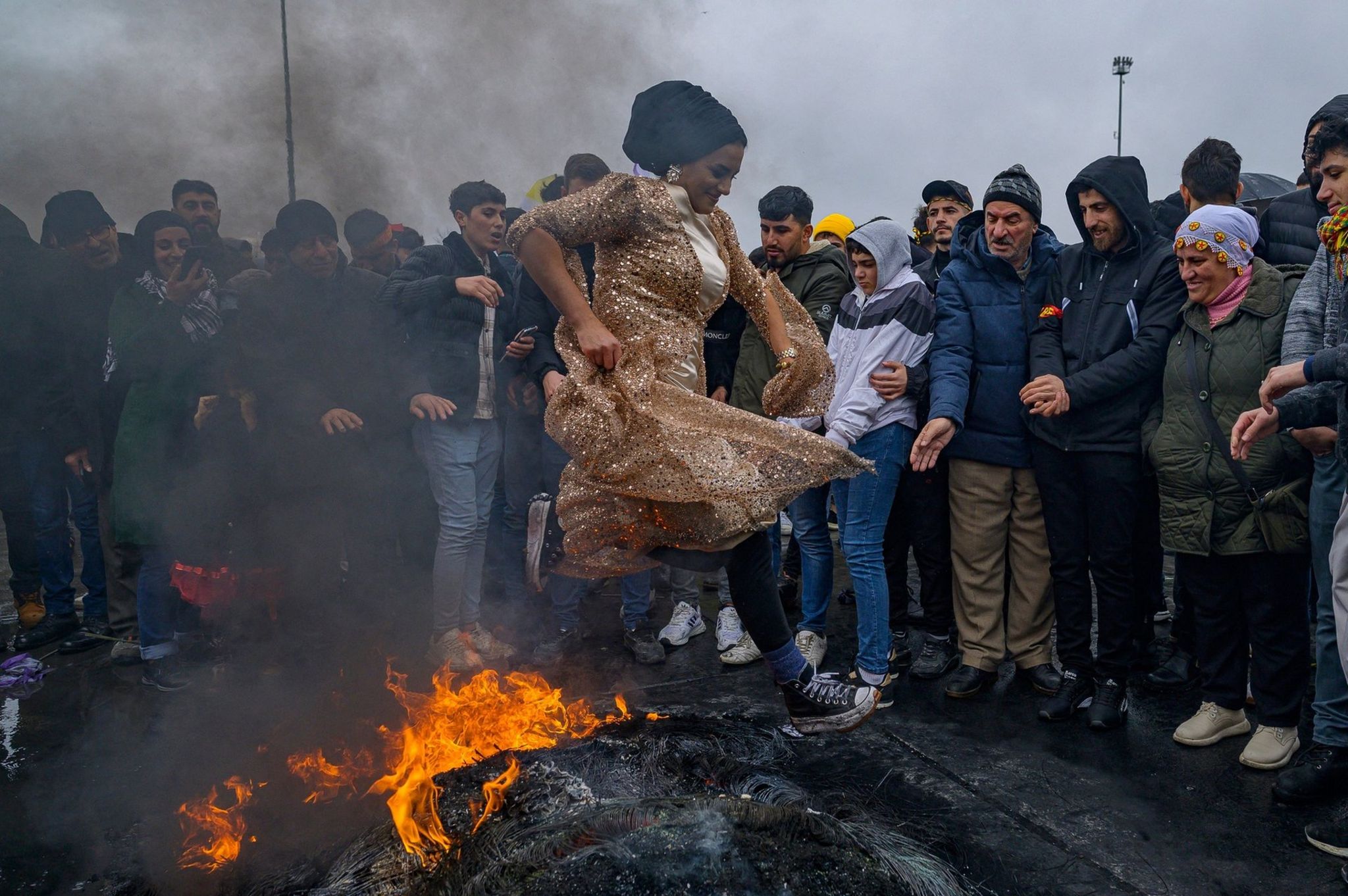 A woman jumps over fire as part of Nowruz celebrations in Iran