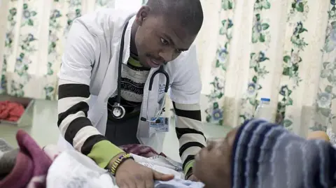 Medical student Lwando Mpotulo (c), age 23, examines a patient in a ward at GF Jooste hospital on October 21, 2010, Cape Town, South Africa