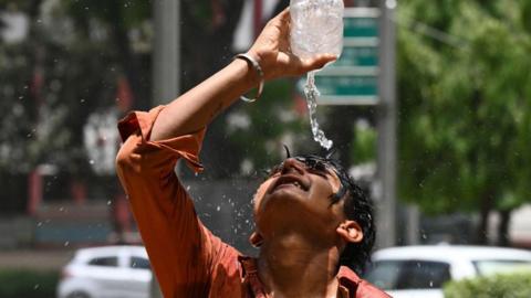 boy pouring water on himself in India