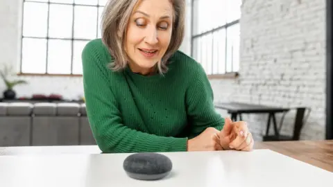 older woman interacting with smart speaker