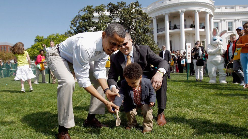 President with smartly dressed young boy rolling an egg on the white house lawn