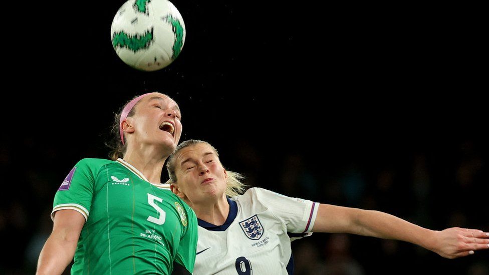 Two football players from England and Republic of Ireland women's teams compete for a header/