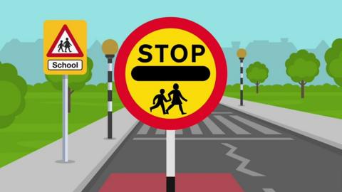 Cartoon sign of a lollipop sign with the word STOP and outline of two people crossing the road