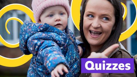 Woman holding baby child wearing a light pink hat with 'Quizzes' written beneath. 