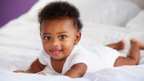 Baby on bed smiling