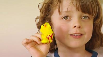 Young boy holding a small plastic Easter chicken.